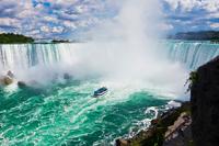 Cataratas del Niágara: Excursión de un día por aire desde Nueva York
Le recogerán en su hotel en el centro de Manhattan y le llevarán al aeropuerto para que tome el vuelo con destino al norte del estado de Nueva York (de una hora de duración aproximadamente). A su llegada, le estará esperando el guía de la excursión y un autobús para ir a las cataratas del Niágara. Tras el almuerzo, subirá a bordo de un barco para disfrutar de las cataratas del Niágara de cerca. Este crucero de 30 minutos de duración le llevará entre las aguas espumosas al pie de las cascadas americanas y de las cascadas en forma de herradura (Horseshoe Falls). Se acercará tanto que la bruma fresca le tocará la piel. Los cruceros en barco de las cataratas del Niágara zarpan únicamente durante los meses más cálidos, normalmente de mayo a octubre. Por tanto, si realiza su viaje entre noviembre y abril puede que en vez de montar en este barco realice el Journey Behind the Falls. Descenderá en ascensor por detrás la gran cascada para ver un ensordecedor primer plano de las cataratas del Niágara. Tenga en cuenta que, dependiendo de las condiciones meteorológicas, es posible que los cruceros en barco de las cataratas del Niágara dejen de funcionar antes del 31 de octubre. Debido a la extrema popularidad de esta visita, se requiere una reserva anticipada de como mínimo 5 días. Nota importante: en el momento de efectuar la reserva se le pedirá que proporcione el nombre y la fecha de nacimiento de cada pasajero, tal y como figuran en su pasaporte. También será necesario que indique los datos del hotel para que el proveedor puede programar la recogida. Si no se incluye esta información, no se puede hacer la reserva. Cualquier cambio de nombre después de la confirmación, lo hará incurrir en una tasa de modificación por parte del proveedor de servicios directamente. Cataratas del Niágara: Excursión de un día por aire desde Nueva York