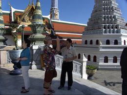 Photo of Wat Phra Kaew Tour Our Guide, Chan, sharing information with one of the tourists , Carine888 - December 2013