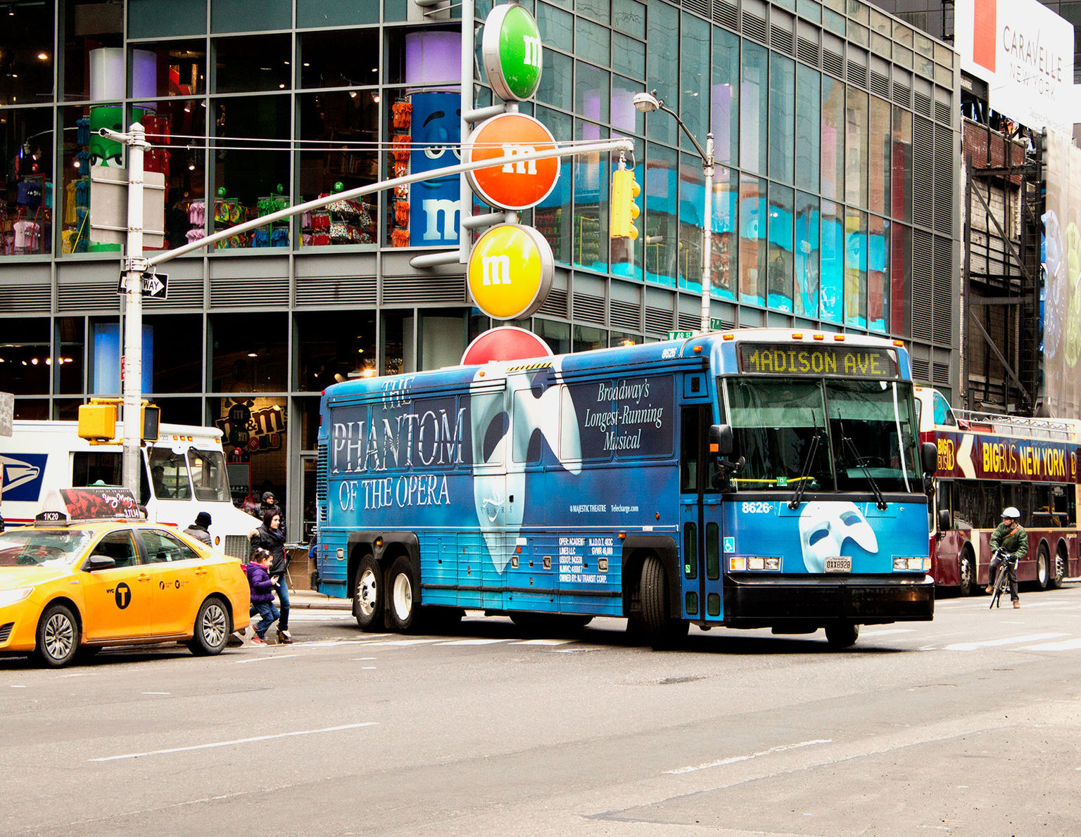 Phantom of The Opera coach driving past m and m's Time Square NY