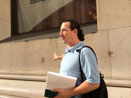 Photo of Tom at Work Tom points out the damage left from the Wall Street bombing of 16 September 1920--almost exactly 94 years from the day of our tour. , Steven S - September 2014