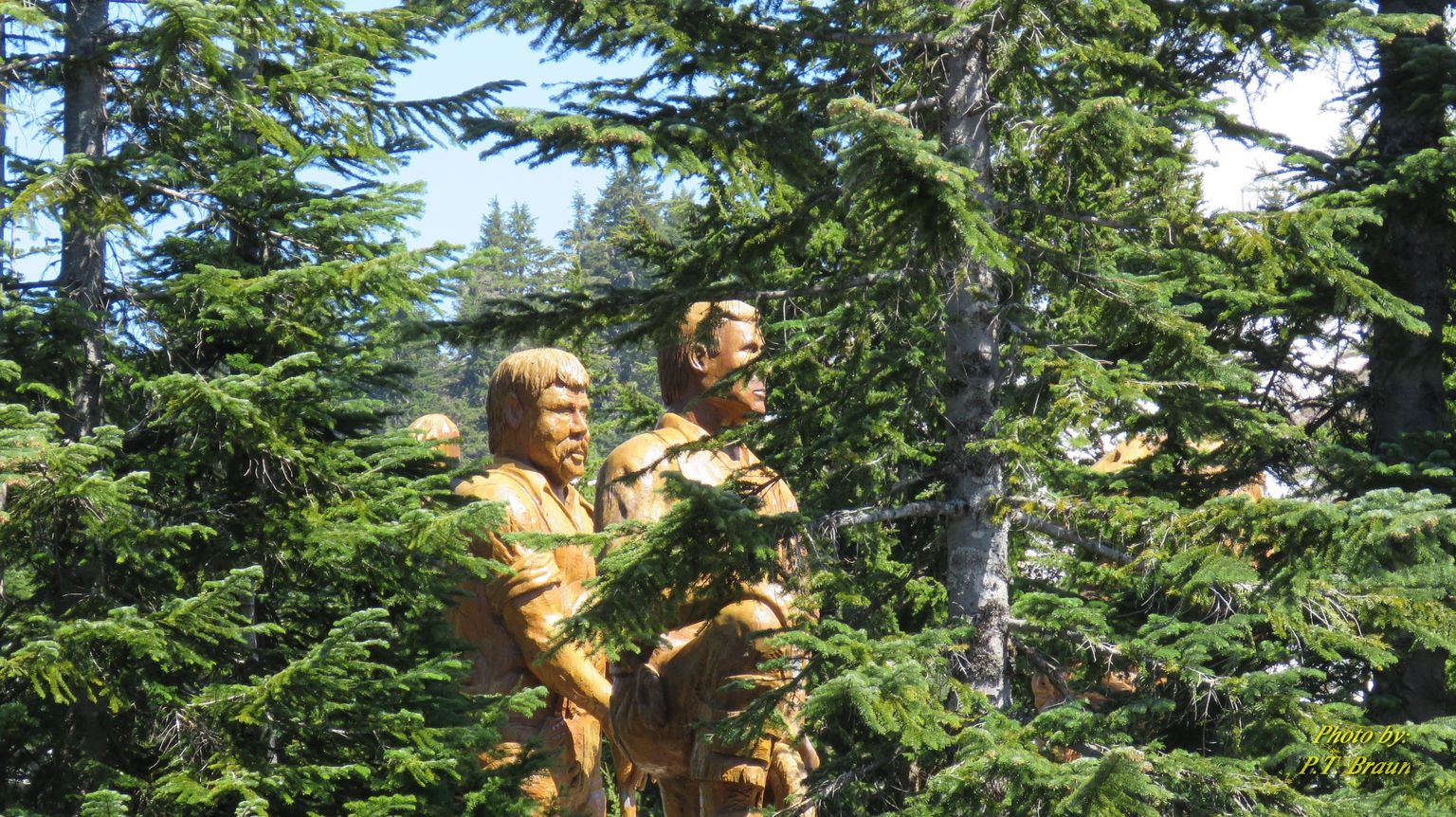 A carving representing the lumberjacks who made use of the land possible.