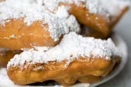Photo of Plate of Hot Beignets, New Orleans Powdered sugar is loaded onto hot, crispy beignets at Cafe Du Monde in New Orleans - May 2011