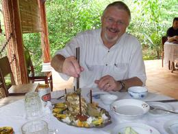 Photo of Eating - Mekong River Cruise Lunch on the island part of the tour, the remains of the Elephant Ear Fish being attacked by Gary - November 2011