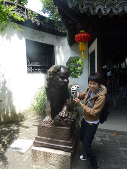 Photo of Tour Guide Mary and Sock puppet at Yuyuan Garden in Shanghai Mary and Sock Puppet posing with a female lion at the Yuyuan Garden in Shanghai. She loved Sock Puppet, and used him to help her guide our entire tour! , Jamey F - May 2015