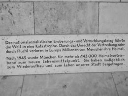 Photo of Plaque noting the Nazi Partys role in WWII This plaque is on the wall inside the arch way of the new Town Hall leading off Marieplatz. This plaque notes that the Nazi Party initiated a world catastrophe, i.e. WWII, and caused millions of ... , Jennifer N - August 2015