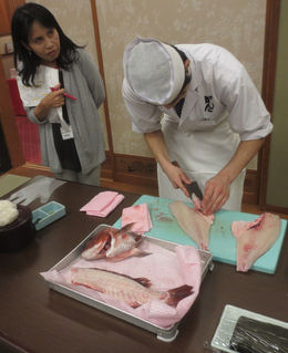 Photo of Demonstration Our guide standing next to a sushi chef that is demonstrating how to fillet a fish. , Bill604 - November 2015